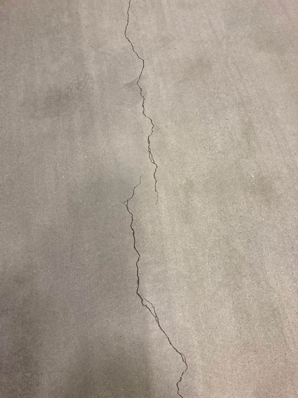 In the logistics center, multiple cracks and wear were observed on the polished concrete flooring due to prolonged use and heavy traffic from forklifts, reach trucks, and personnel.