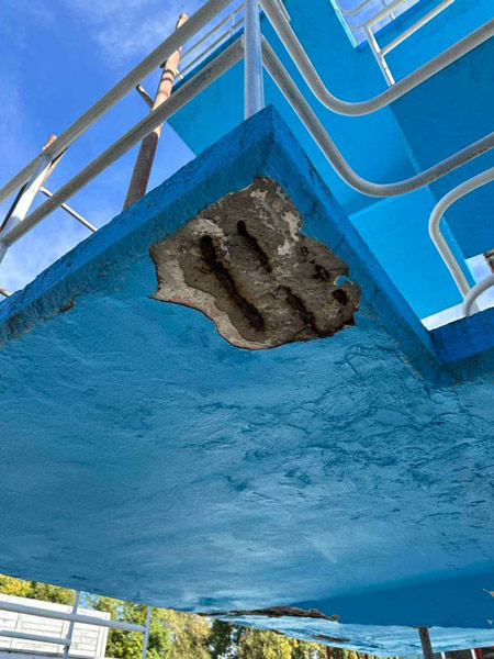 Detail of the collapsed concrete of the diving tower with signs of advanced corrosion and concrete destruction.