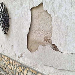 Разрушена мазилка на зидана обграда, вследствие капилярно покачваща се влага.