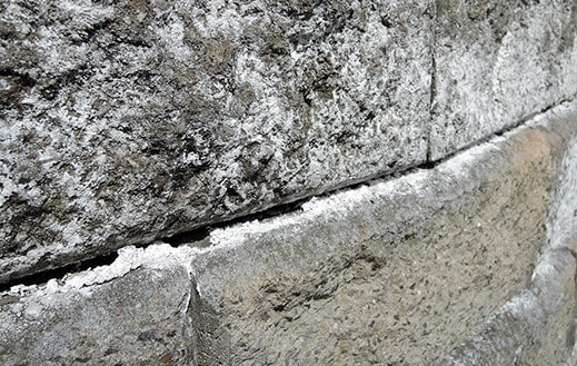 масирано излужване на калциев хидроокис от бетона и образуване на калциев карбонат по повърхността на нетретирани с хидрофобизатор елементи.