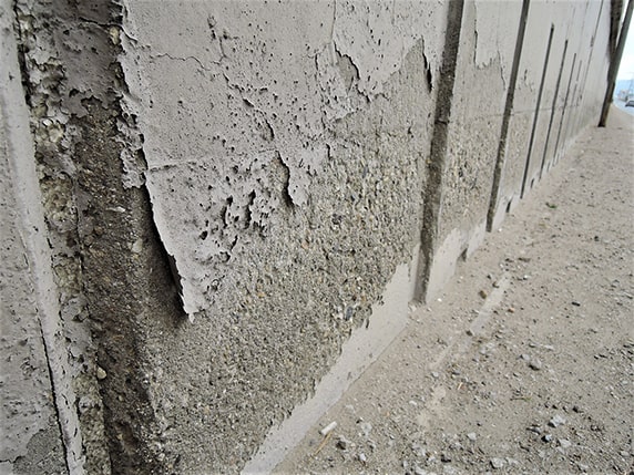 Снимка 1: Разрушаване на покритие върху бетон, както и бетонът под него вследствие на капилярно проникваща вода в бетона под покритието.